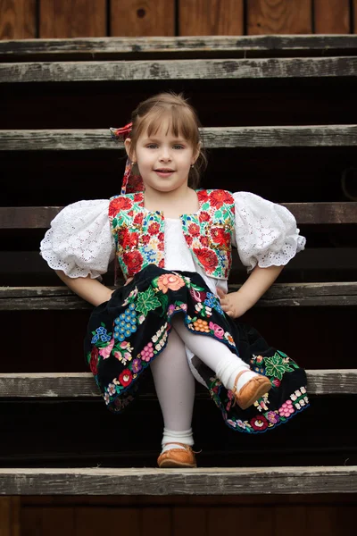 Sitting little girl in traditional costume — Stock Photo, Image