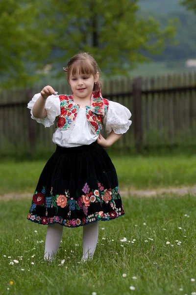 Petite fille en robe traditionnelle sur la prairie — Photo