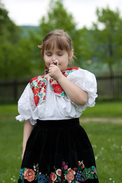 Little girl in traditional costume with flowers — Stock Photo, Image