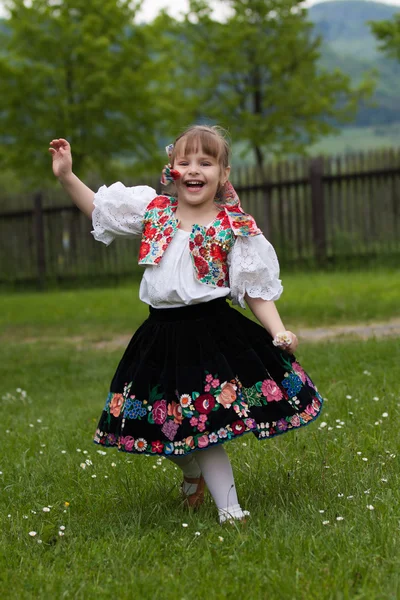 Little girl in traditional costume with flowers — Stock Photo, Image