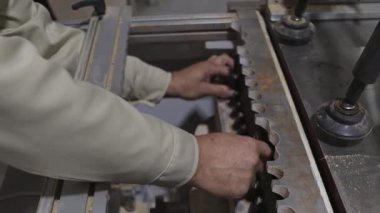 Marangozluk makinesinin kesicisini değiştirmek. İşçinin ellerine yakın çekim..