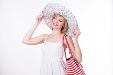 Kırmızı beyaz holding zarif şapkalı güzel kadın çanta çıkardı. Gülümseyen kadın moda. İzole