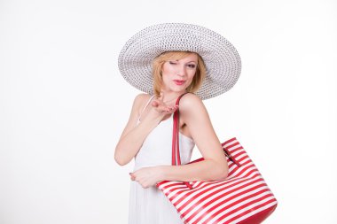 Kırmızı beyaz holding zarif şapkalı güzel kadın çanta çıkardı. Gülümseyen kadın moda. İzole