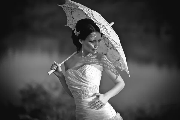 Schöne Braut im Brautkleid mit Regenschirm, im Freien Porträt. schwarz-weiß — Stockfoto