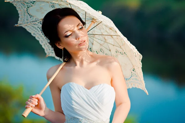 Beautiful bride in wedding dress with white umbrella, outdoors portrait — Stock Photo, Image