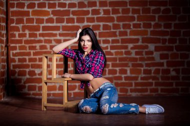 Kameraya bakarak çekici genç güzel esmer kadın. Kotun içinde poz uzun siyah saçlı seksi kız.