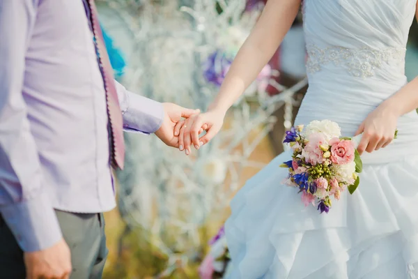 Pareja casada joven y feliz cogida de la mano. Romance. — Foto de Stock