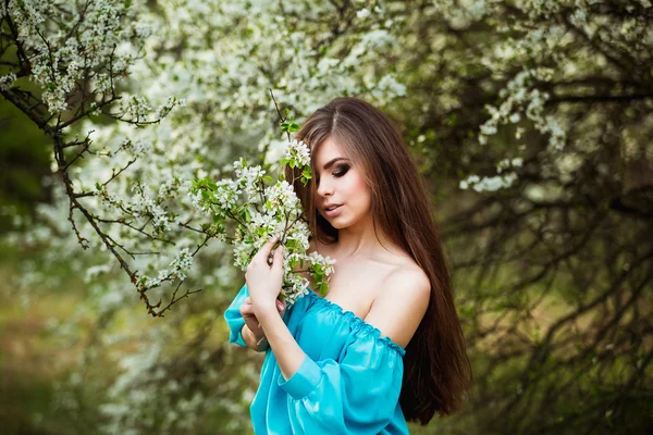 Beautiful young woman with long healthy hair relaxing at blossom park. — Stock Photo, Image