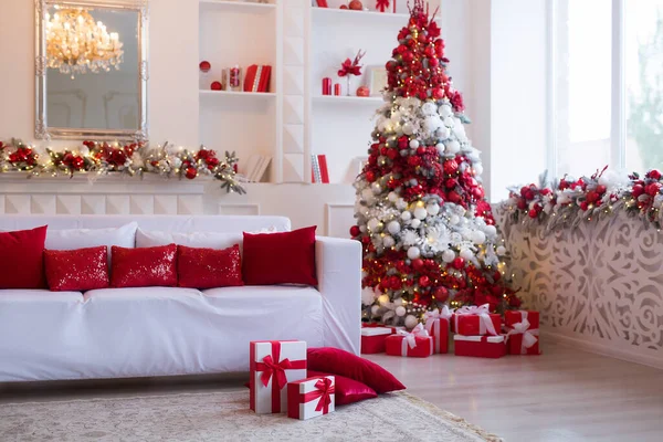 Interior of bright modern living room with fireplace and comfortable sofa decorated with Christmas tree and gifts — Stock Photo, Image