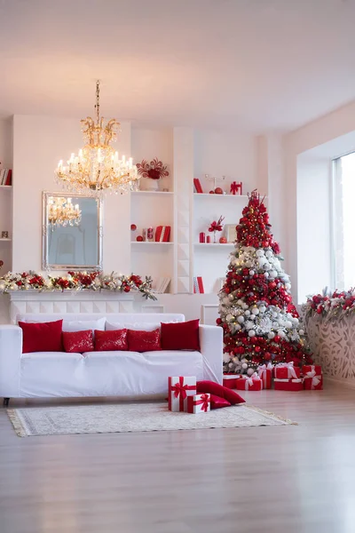 Interior of bright modern living room with fireplace and comfortable sofa decorated with Christmas tree and gifts — Stock Photo, Image