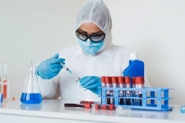 Doktor elinde şırınga ve aşı tutan eldivenleri teslim etti. Korona virüsünden korunma, aşılama ve tedavi, baca, enfeksiyon. Aşı, iğne, ilaç kavramı.