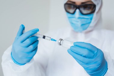 Ellerinde şırınga ve aşı olan yakın plan doktor elleri. Korona virüsünden korunma, aşılama ve tedavi, baca, enfeksiyon. Aşı, iğne, ilaç kavramı.