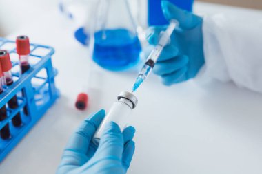 Ellerinde şırınga ve aşı olan yakın plan doktor elleri. Korona virüsünden korunma, aşılama ve tedavi, baca, enfeksiyon. Aşı, iğne, ilaç kavramı.