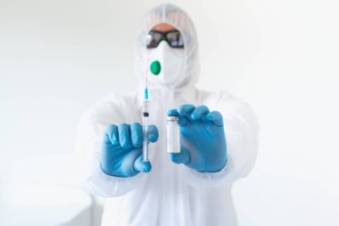 Ellerinde şırınga ve aşı olan yakın plan doktor elleri. Korona virüsünden korunma, aşılama ve tedavi, baca, enfeksiyon. Aşı, iğne, ilaç kavramı.