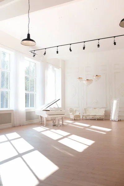 Riche intérieur de luxe d'une chambre de style classique avec mobilier vintage, grandes fenêtres, miroir, lustres et piano à queue. — Photo