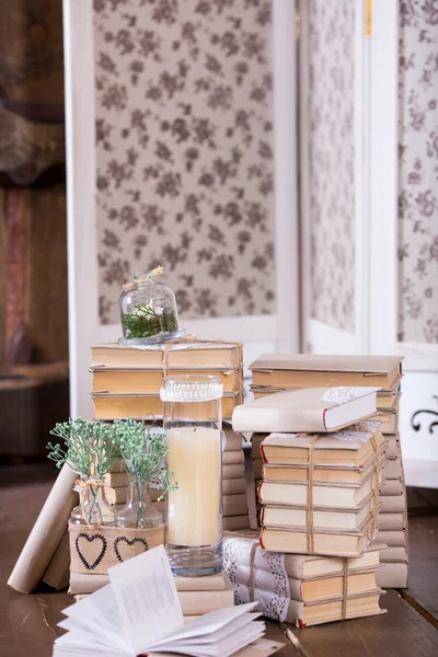 Alte Bücherhaufen und Kerzen in Vintage-Innendekoration — Stockfoto