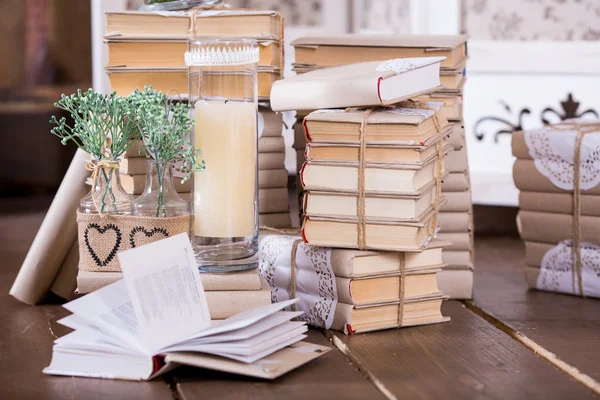 Oude boeken heap en candle in interieur decoratie — Stockfoto