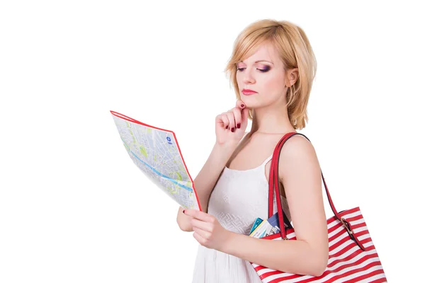 Young cute girl with red bag looking at map before travel. Isolated — Stock Photo, Image