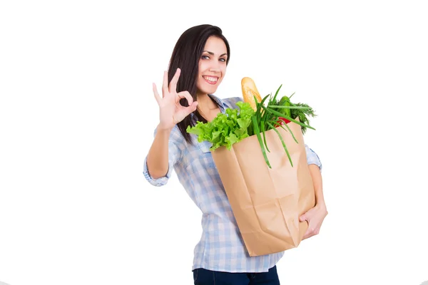 Mujer joven feliz sosteniendo bolsa de papel con comestibles. Cliente sonriente. Consumismo. Aislado sobre fondo blanco — Foto de Stock