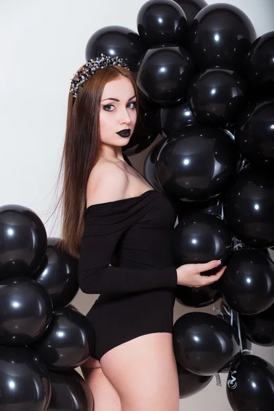 Mujer joven atractiva con cuerpo perfecto y maquillaje de moda con lencería negra. Hermosa modelo posando sobre fondo blanco sosteniendo globos —  Fotos de Stock