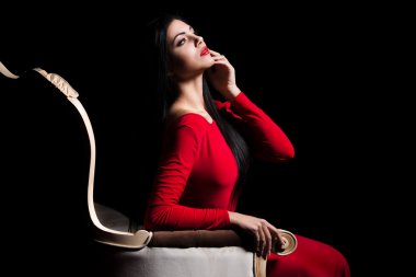  Elegant woman in red dress in darkness. Female in dramatic light