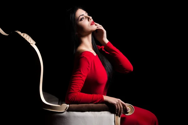 Elegant woman in red dress in darkness. Female in dramatic light — ストック写真