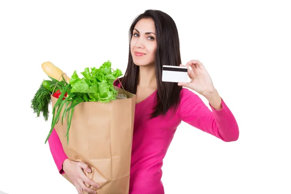 Красива молода жінка з кредитною карткою тримає продукти в еко-паперовій сумці. Жіночий споживач у продуктовому магазині. Ізольовані — стокове фото