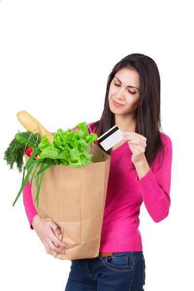 Hermosa joven con tarjeta de crédito sosteniendo comestibles en bolsa de papel ecológico. Consumo femenino en la tienda de comestibles. Aislado — Foto de Stock