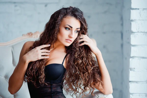Corpo perfeito e sexy de uma jovem mulher usando lingerie preta sedutora. Mulher bonita em bodysuit na cadeira vintage de luxo — Fotografia de Stock
