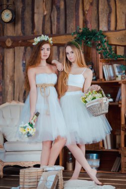 İki güzel şehvetli gelinler giyiyor çiçek tutan vintage iç beyaz ayakta Giydir