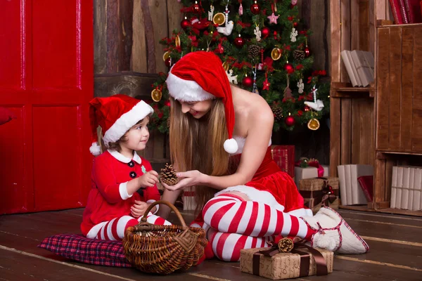 Two Santa girls decorating Christmas tree. New year interior. — Stock fotografie