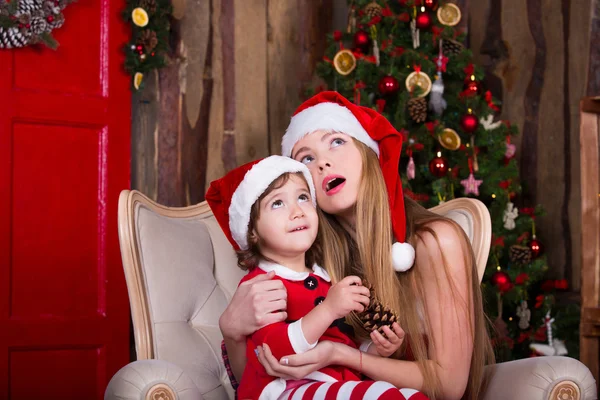 Cute girls sitting with presents near Christmas tree — Stock fotografie