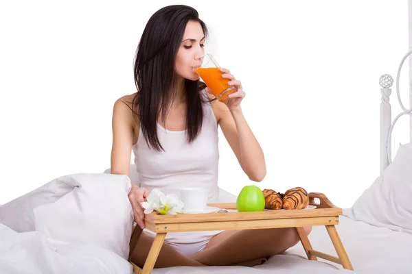 Woman having breakfast in bed. Big continental breakfast. Isolated — Stockfoto