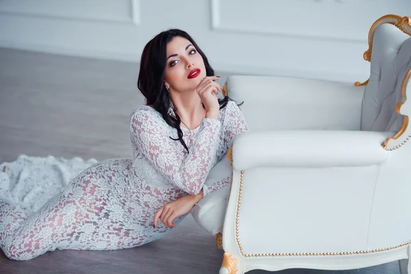 Perfeito, pernas sexy e bunda de jovem mulher vestindo vestido branco sedutor posando perto de cadeira vintage luxo — Fotografia de Stock