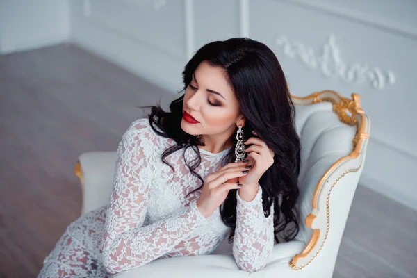 Perfetto, sexy giovane donna che indossa seducente abito bianco seduto sulla sedia vintage di lusso — Foto Stock