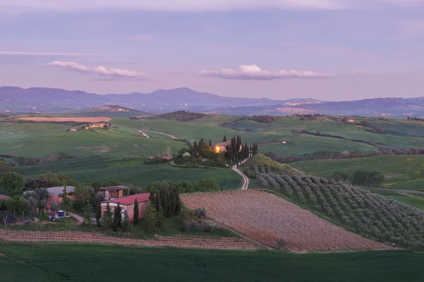 Bauernhaus, grüne Hügel, Zypressen in der Toskana bei Sonnenuntergang — Stockfoto