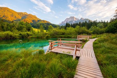 Slovenya 'da gün batımında Kranjska Gora yakınlarındaki Triglav Ulusal Parkı' ndaki Julian Alpleri 'nde güzel Zelenci Gölü