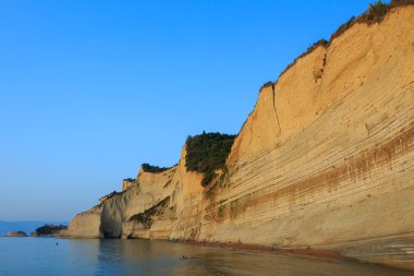 Korfu günbatımında plajda kayalar