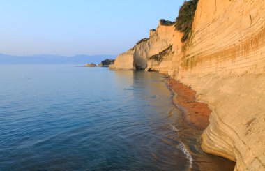 Korfu günbatımında plajda kayalar