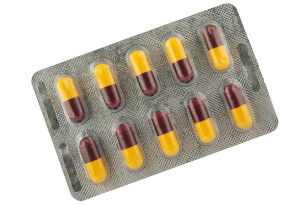 Cápsula marrón y amarilla en blíster muestran concepto de medicamento —  Fotos de Stock