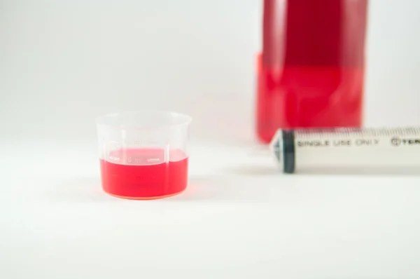 Jarabe de medicina taza de medir plástico y fondo de la medicina — Foto de Stock