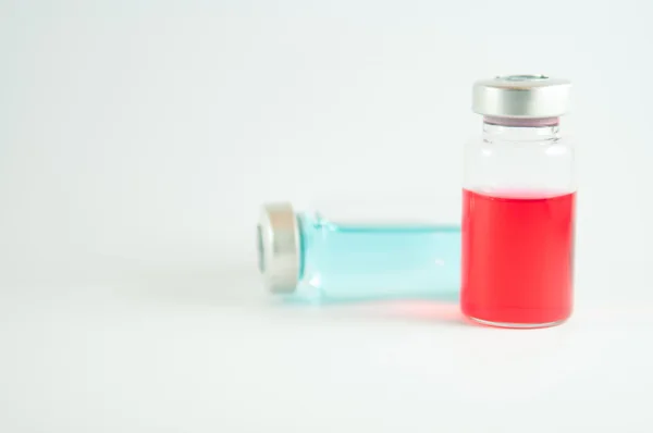 Rode en blauwe vloeistof in injectie flesjes — Stockfoto