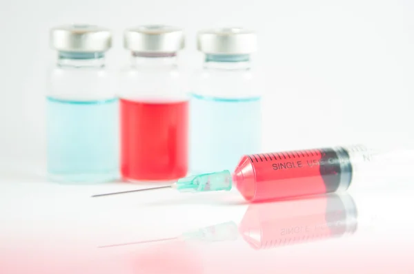 Red liquid in injection syringe and vials — Stock Photo, Image