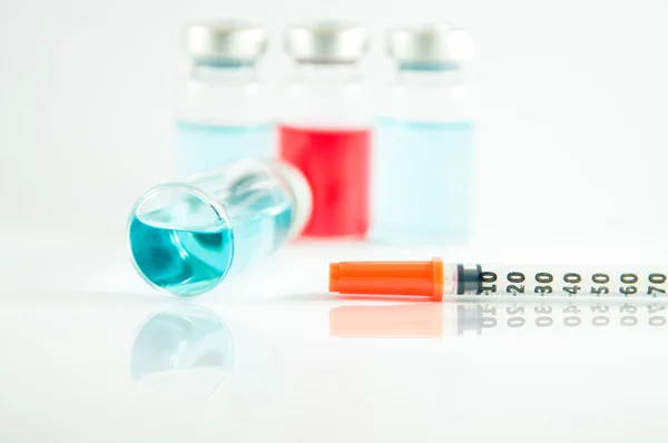 Líquido azul em frasco para injetáveis e seringa — Fotografia de Stock