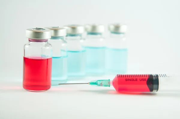 Red liquid in injection syringe and vials — Stock Photo, Image