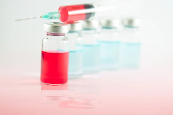 Red liquid in injection syringe and vials — Stock Photo, Image