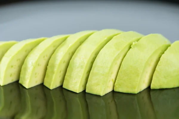 Snijd de avocado groenten op zwarte schotel — Stockfoto