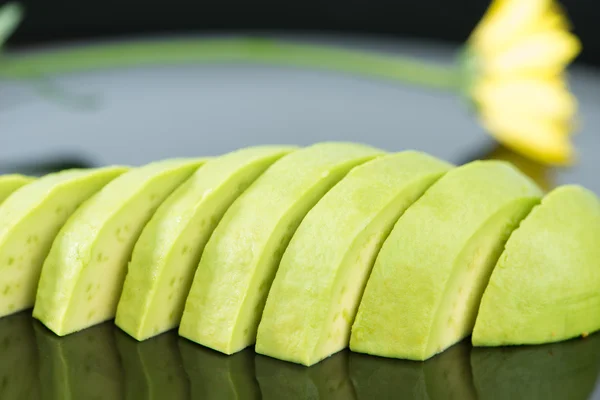 Snijd de avocado groenten op zwarte schotel — Stockfoto