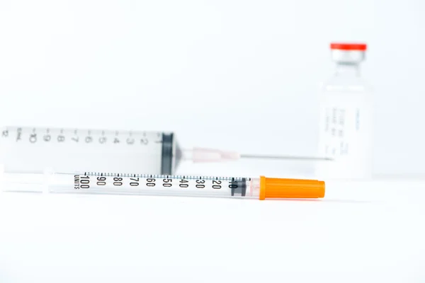Disposable syringe and red cap of injection vial — Stock Photo, Image