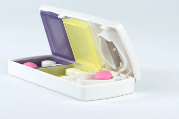 Closed up aluminum blade and pink tablet in pill box — Stock Photo, Image